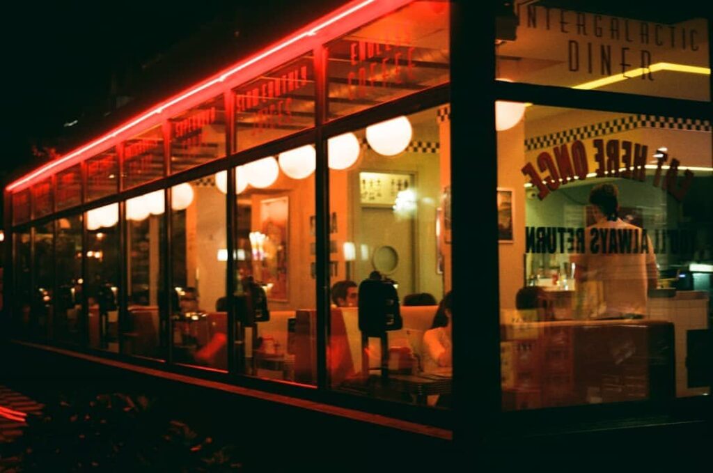 Intergalactic Diner noću spolja, neon i puni separei kroz staklo
